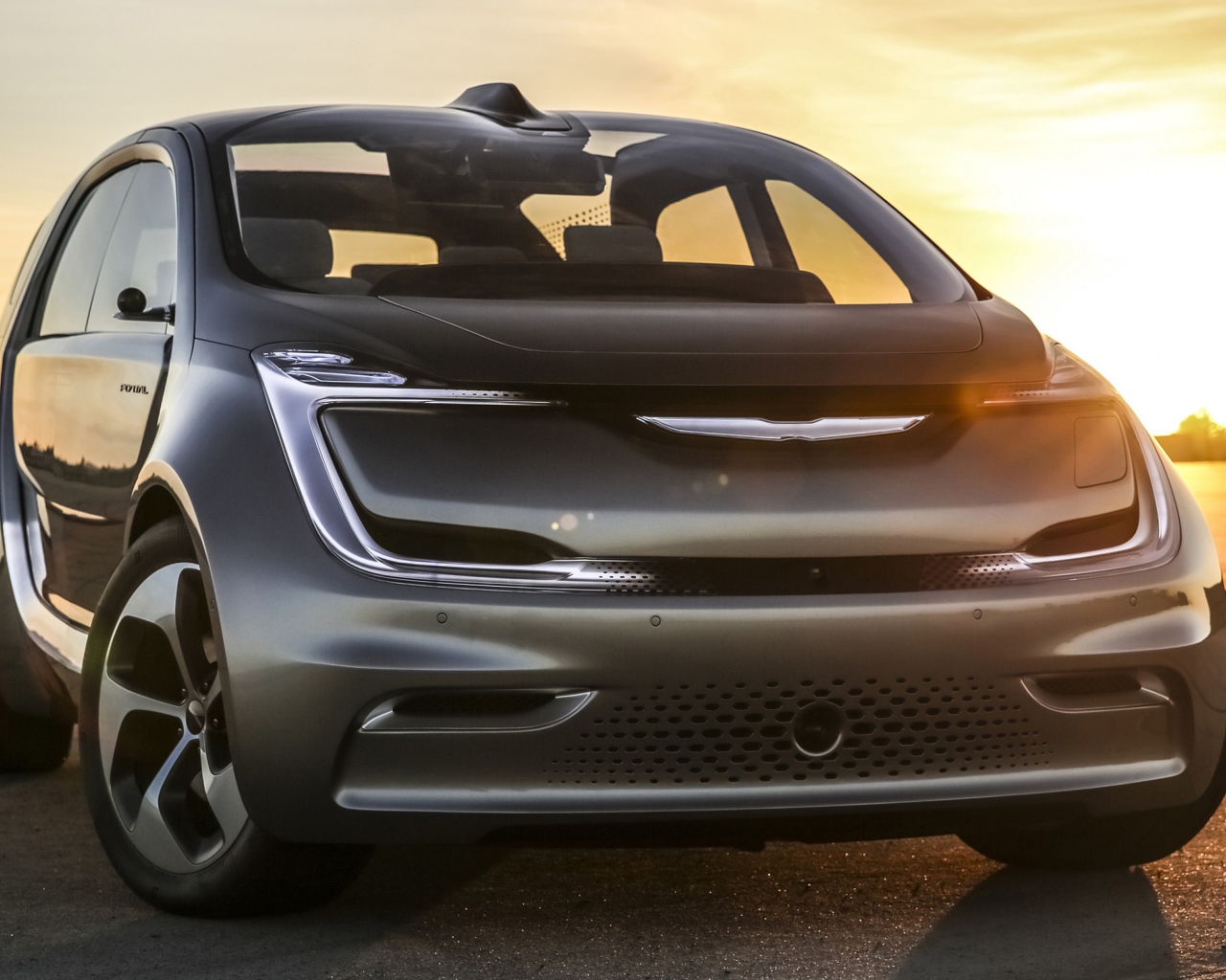 Серебристый электрический автомобиль Chrysler Portal на закате солнца