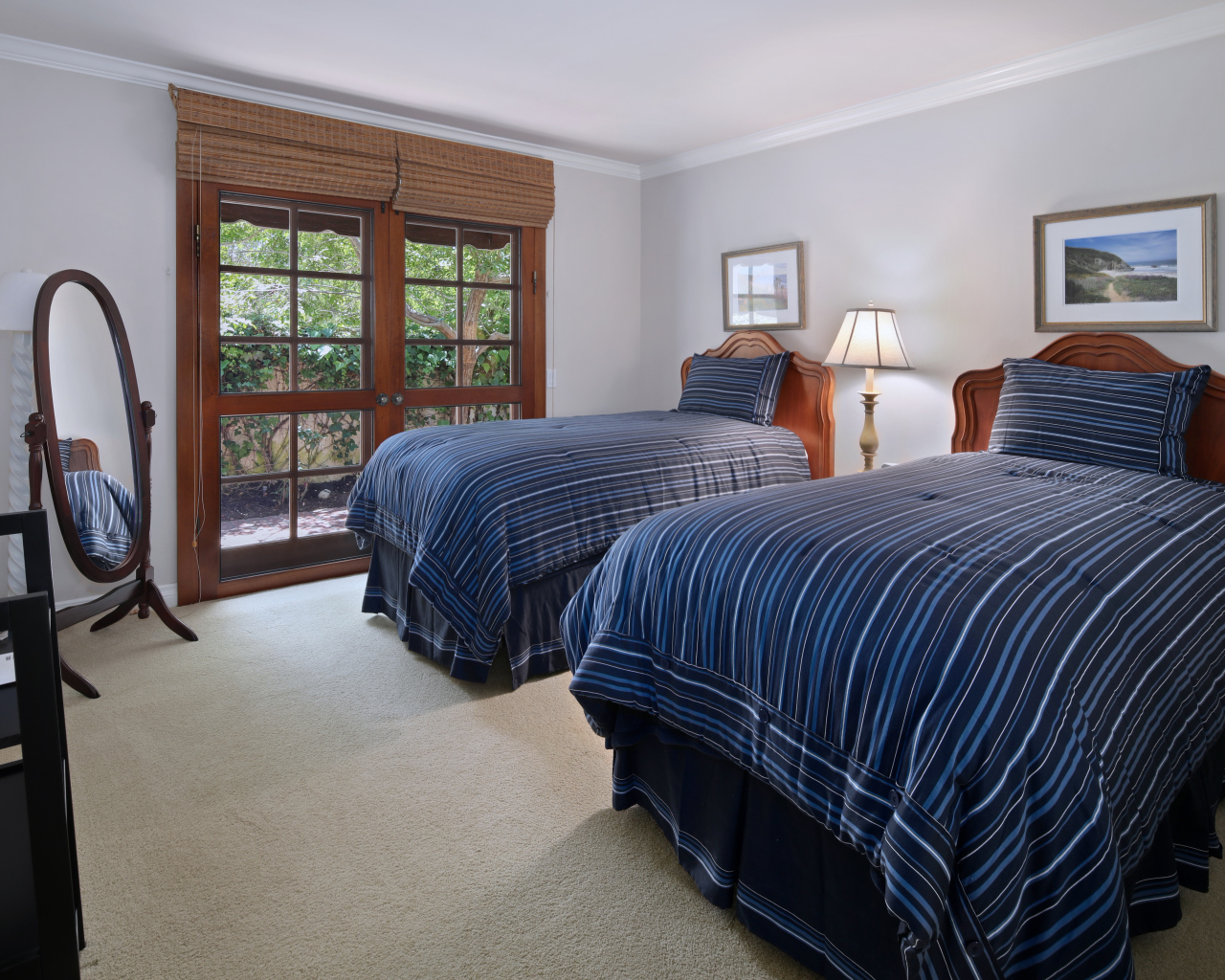 Две большие кровати в спальне с деревянным окном