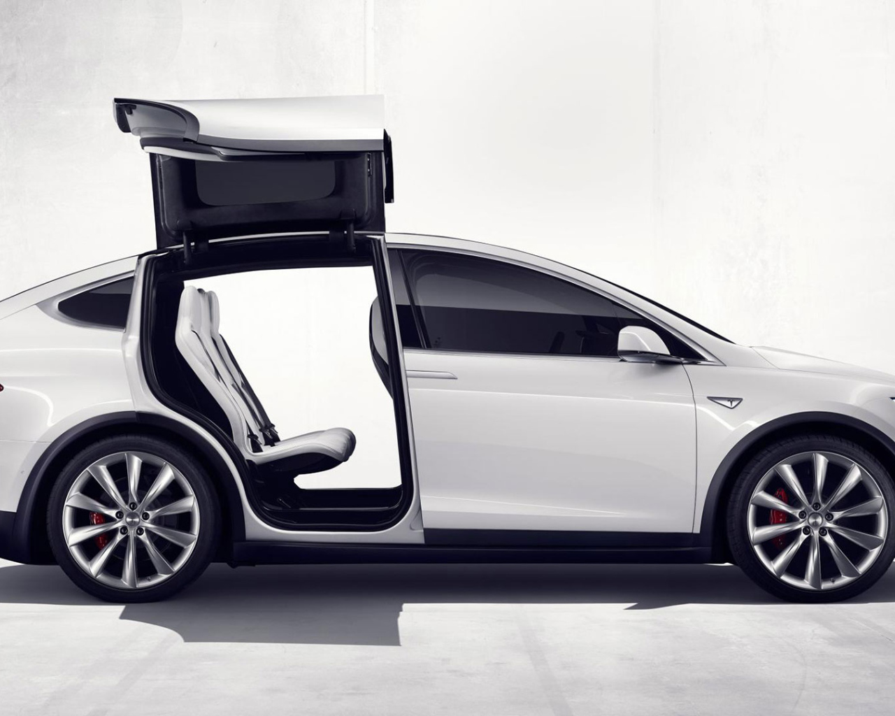 Белый электромобиль Тесла с открытыми дверями  