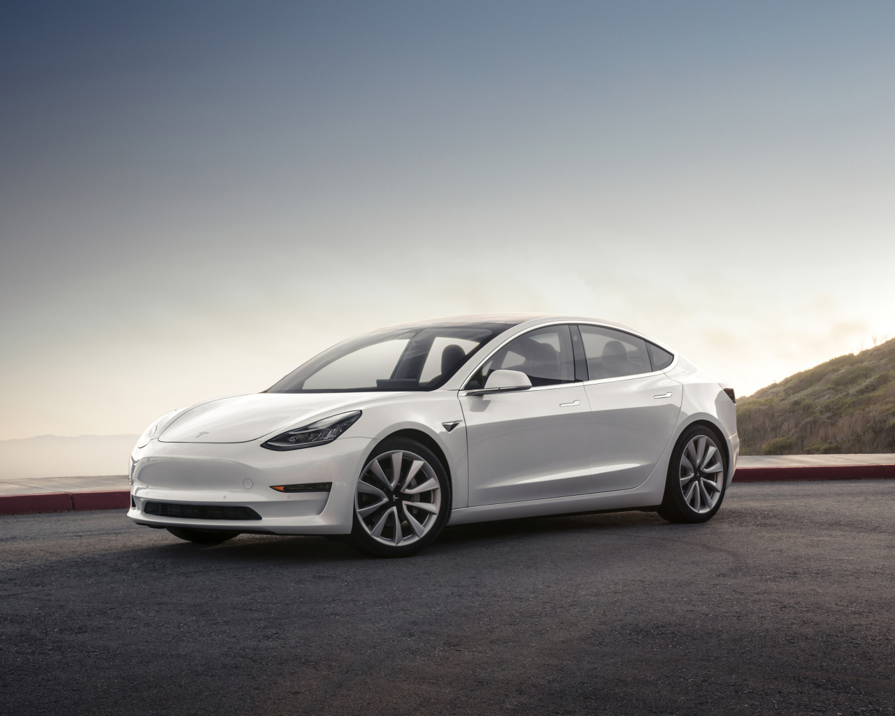 Белый электромобиль Tesla Model 3, 2018 на фоне горизонта