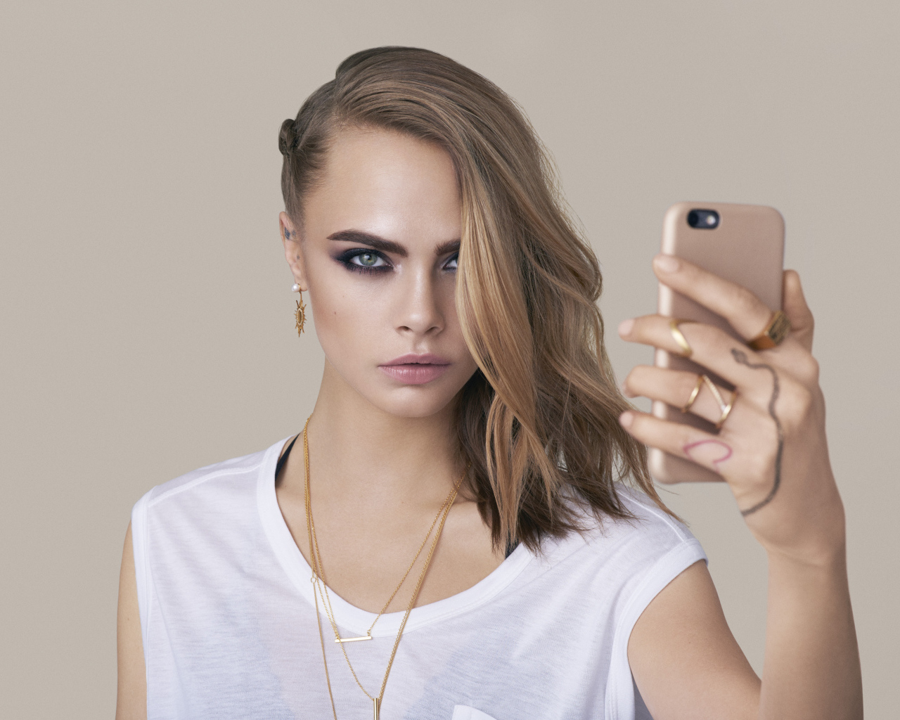 Молодая актриса Кара Делевинь с телефоном в руках