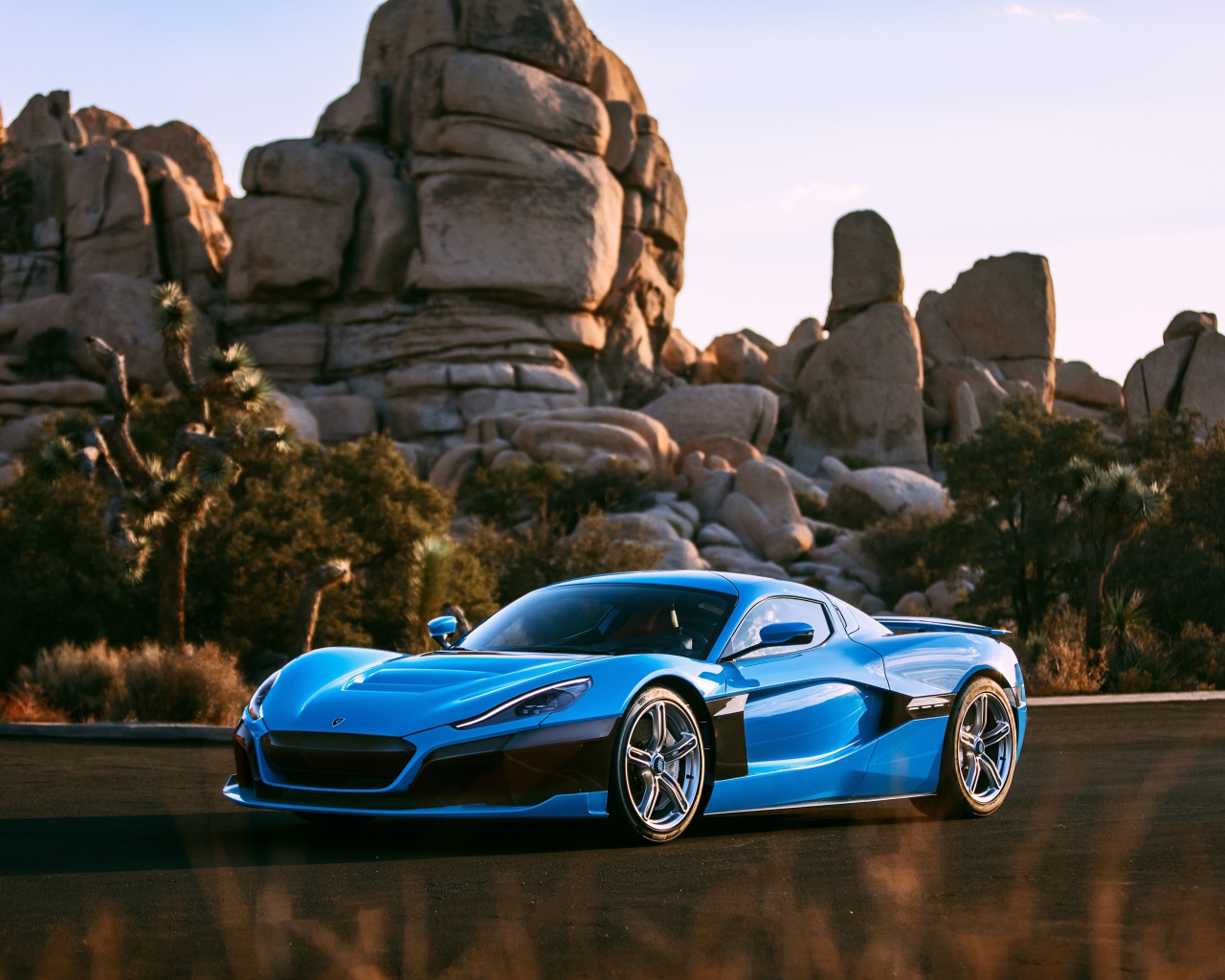 Голубой спортивный автомобиль  Rimac C_Two на фоне гор