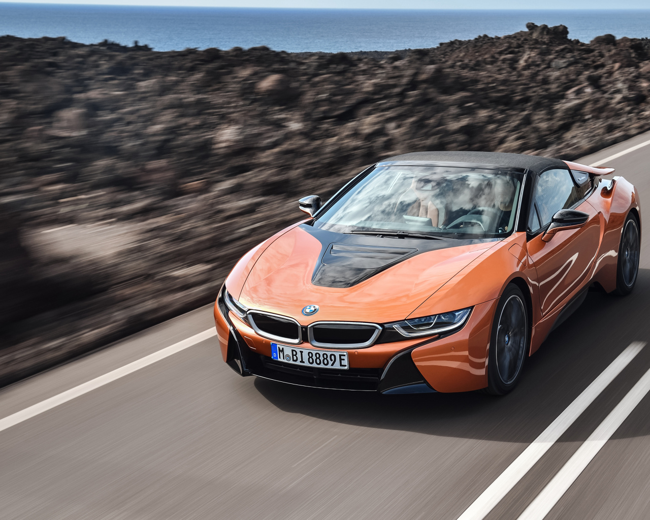 Оранжевый автомобиль BMW i8 Roadster, 2018 на скорости