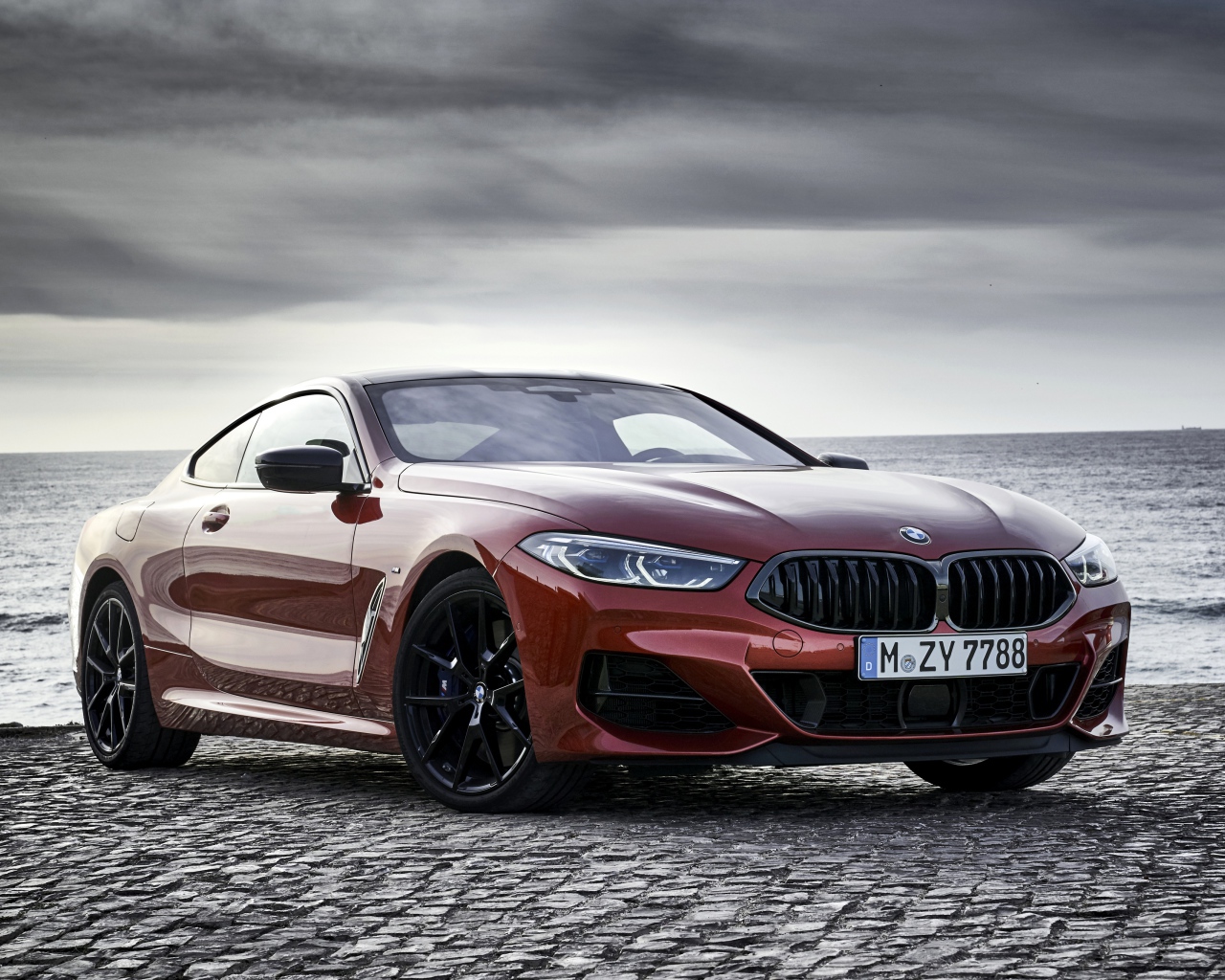 Красный автомобиль BMW 8 Series на фоне моря