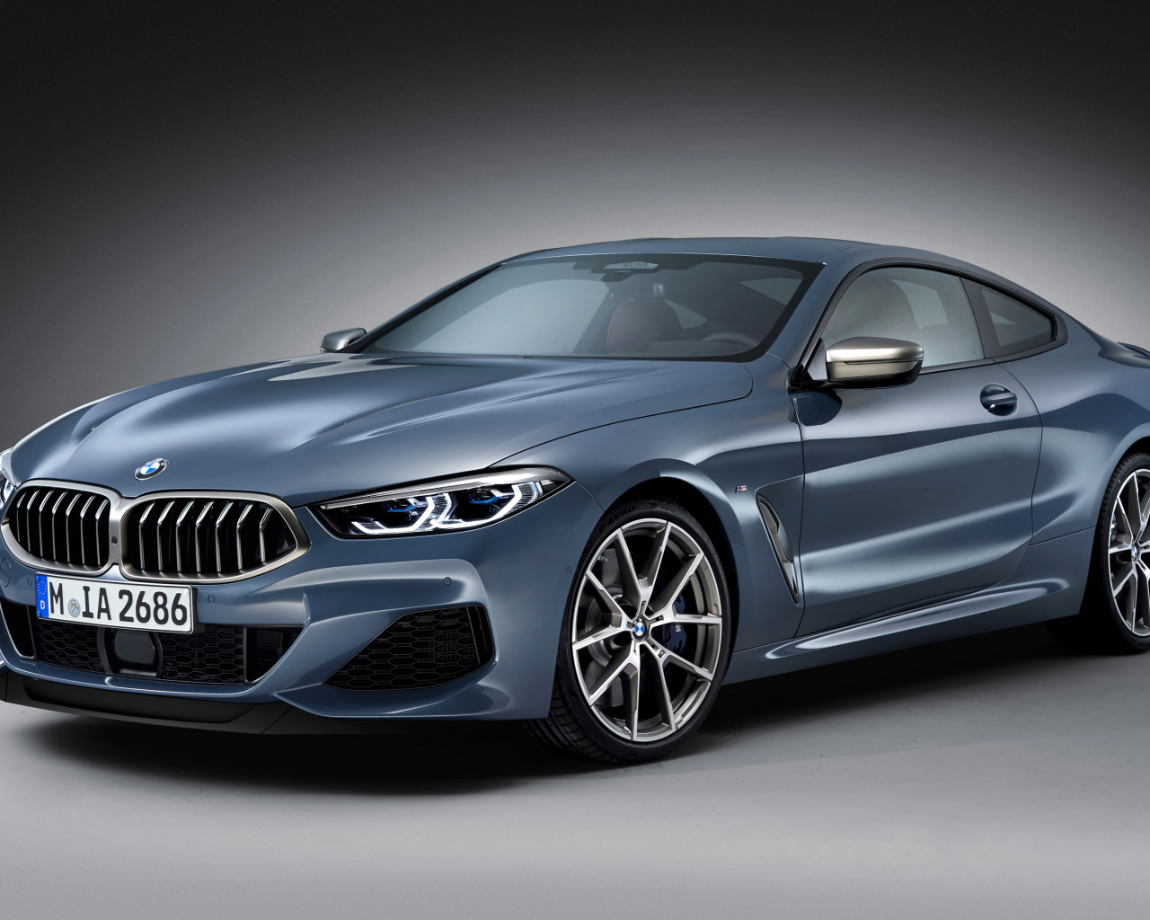 Серебристый автомобиль BMW M850i, 2018 на сером фоне