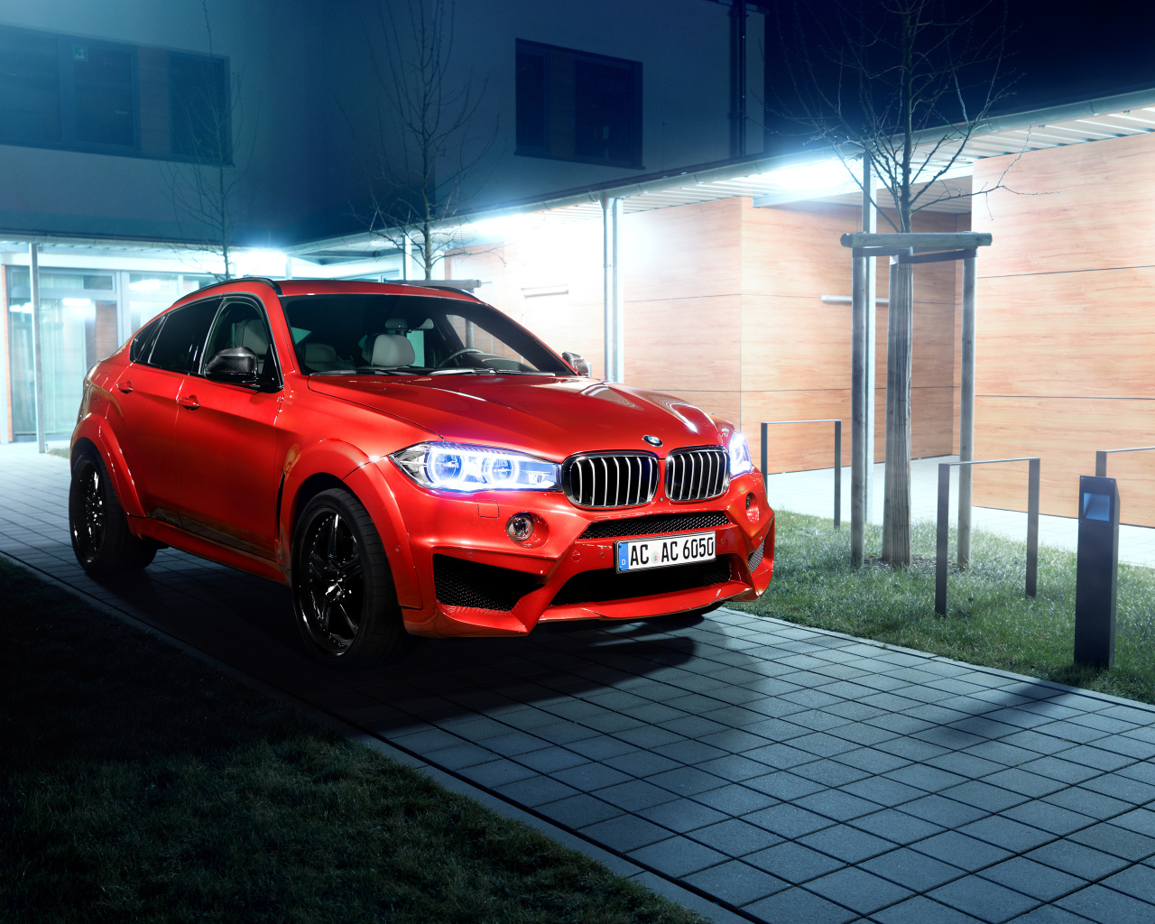 Красный автомобиль BMW X6 на тротуаре