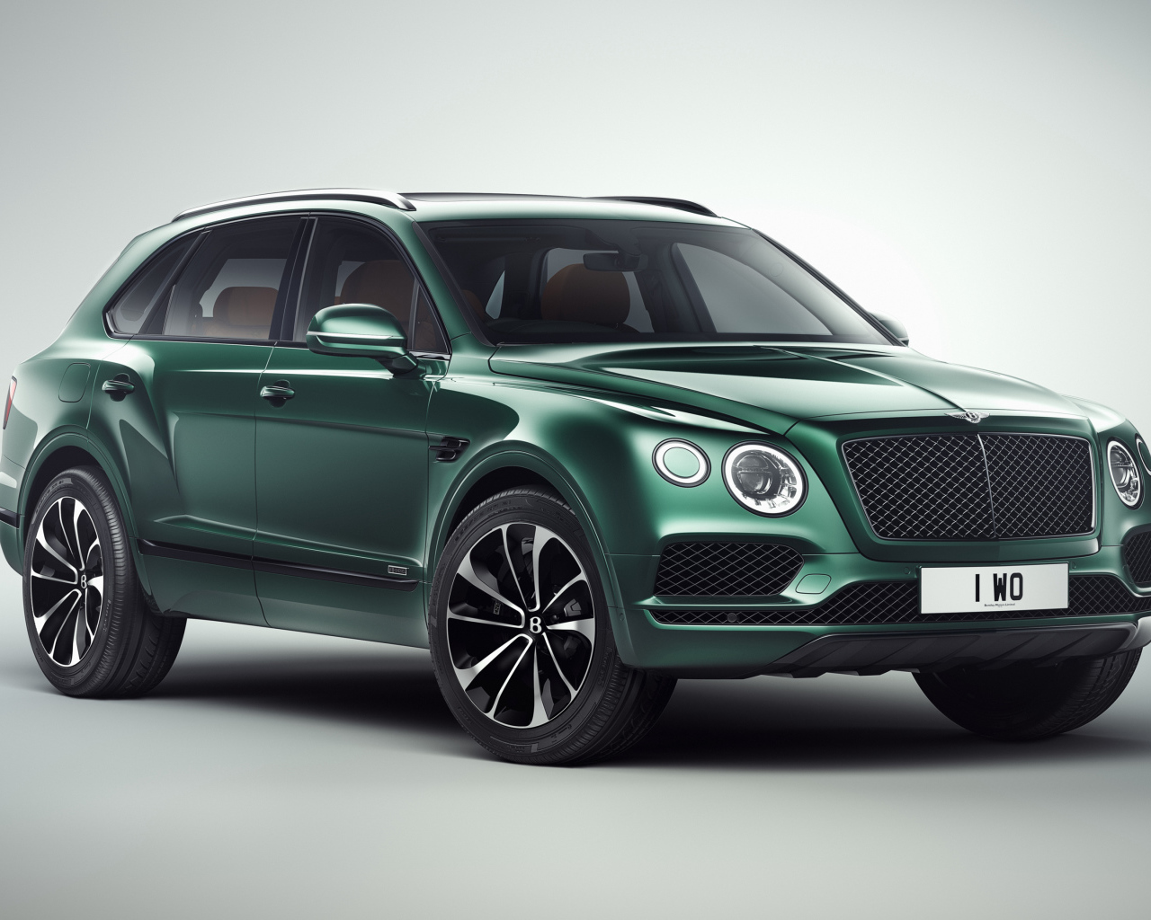 Зеленый автомобиль Bentley Bentayga 2018 года на сером фоне
