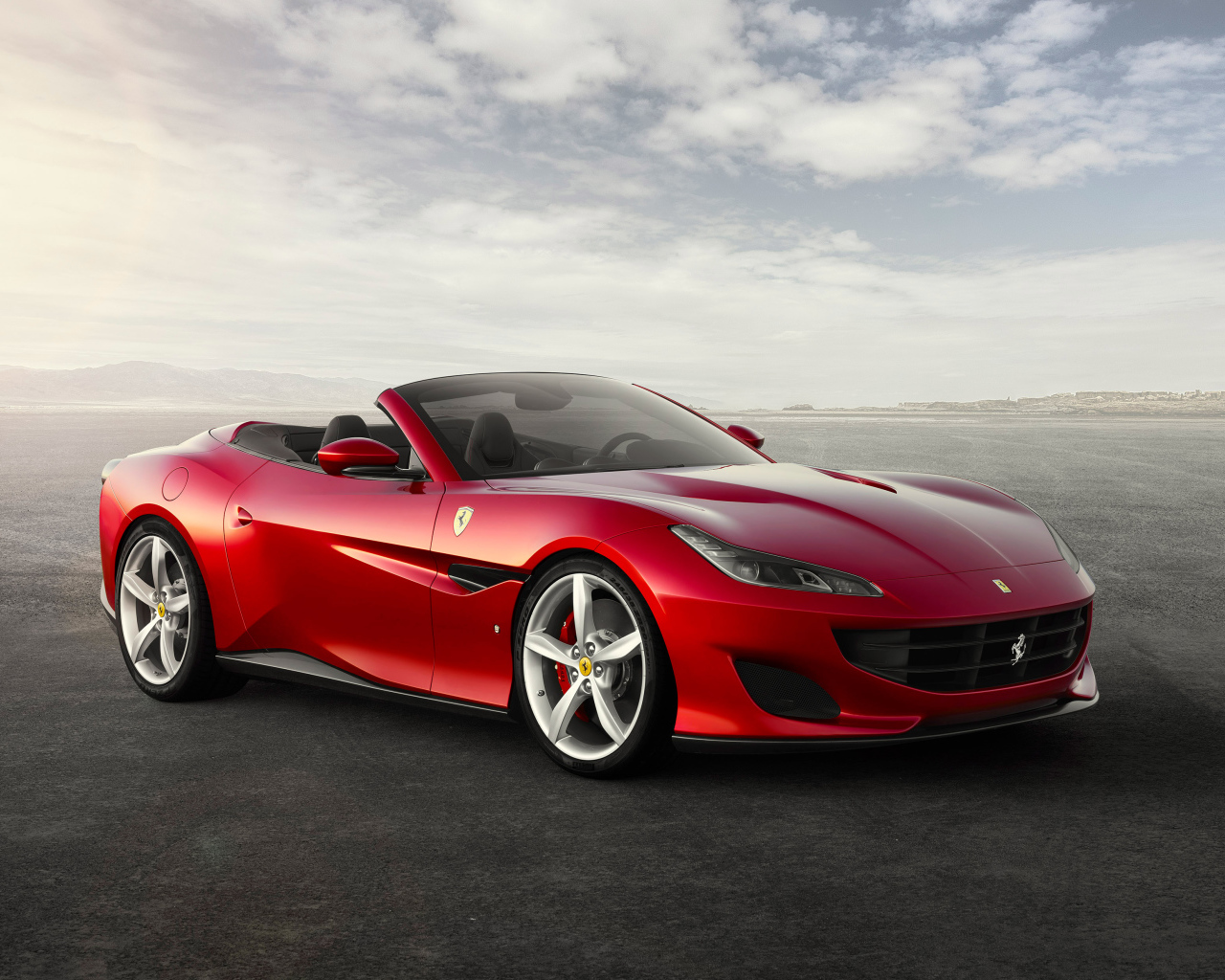 Красный автомобиль кабриолет Ferrari Portofino на фоне неба