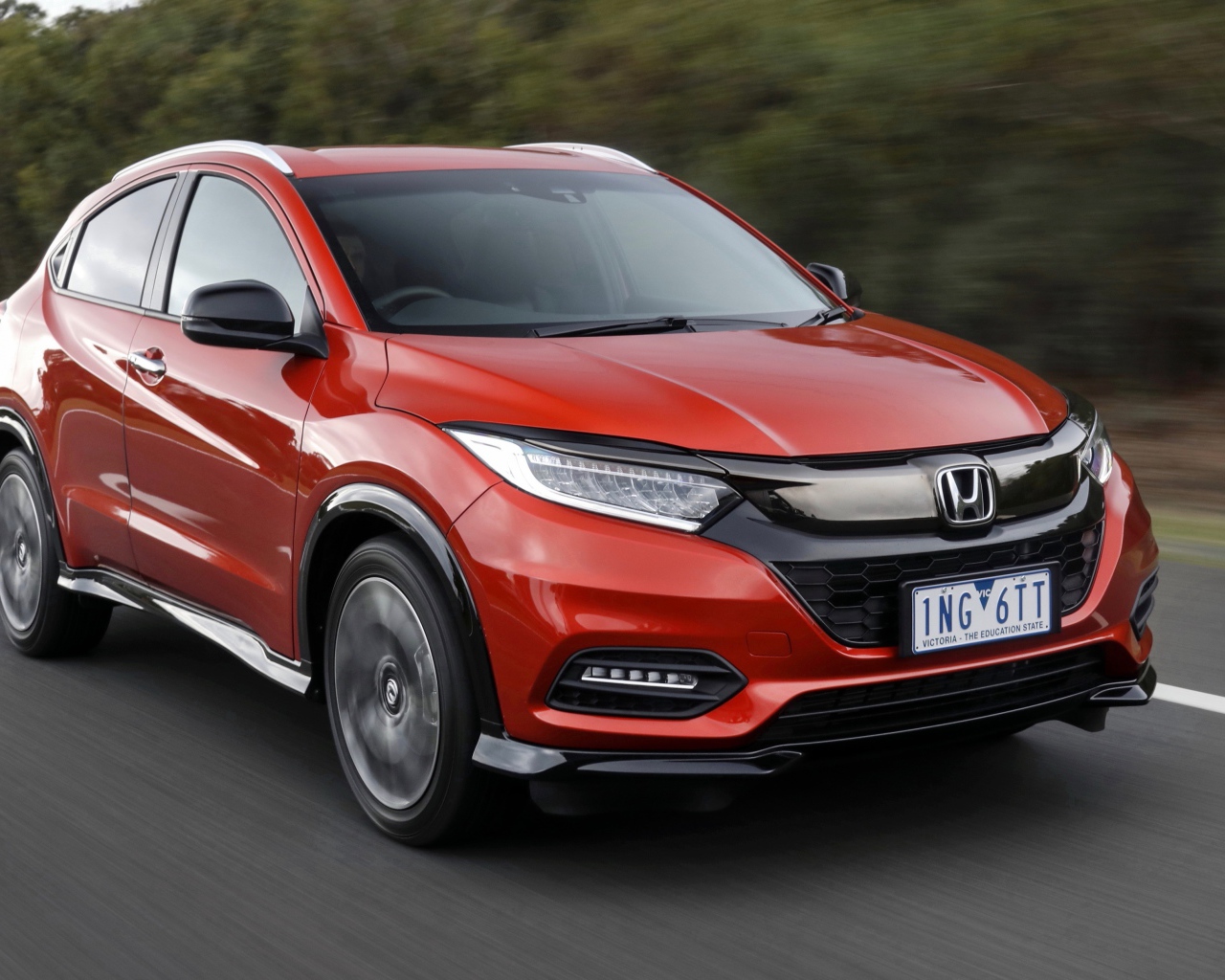 Красный автомобиль Honda HR-V RS 2019 года на трассе
