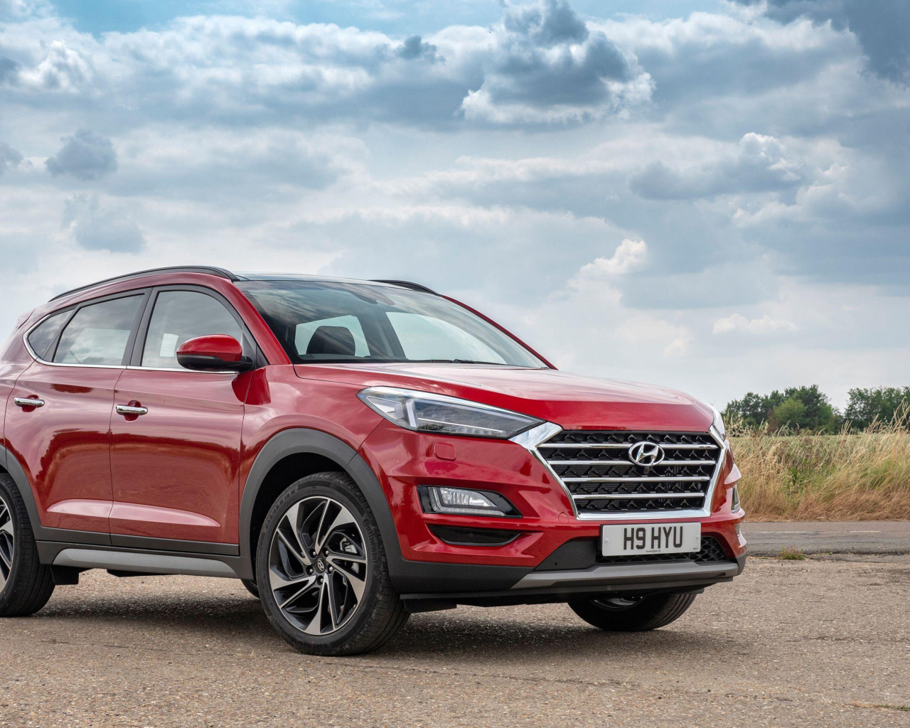 Красный автомобиль Hyundai Tucson, 2019 года под пасмурным небом
