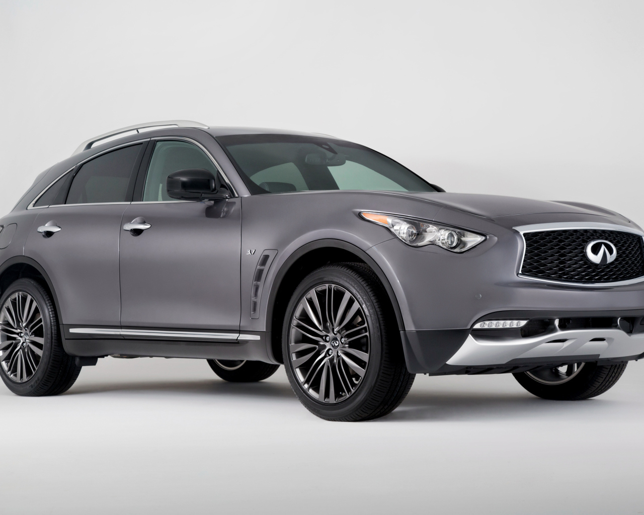 Серебристый автомобиль Infiniti QX70 на сером фоне
