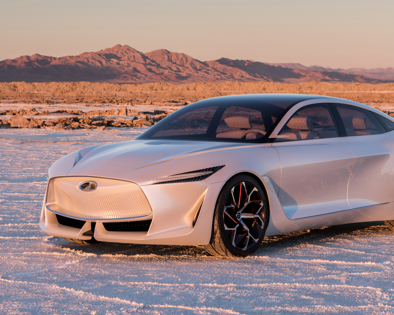 Серебристый автомобиль Infiniti Q Inspiration Concept, 2018 стоит на снегу на фоне гор