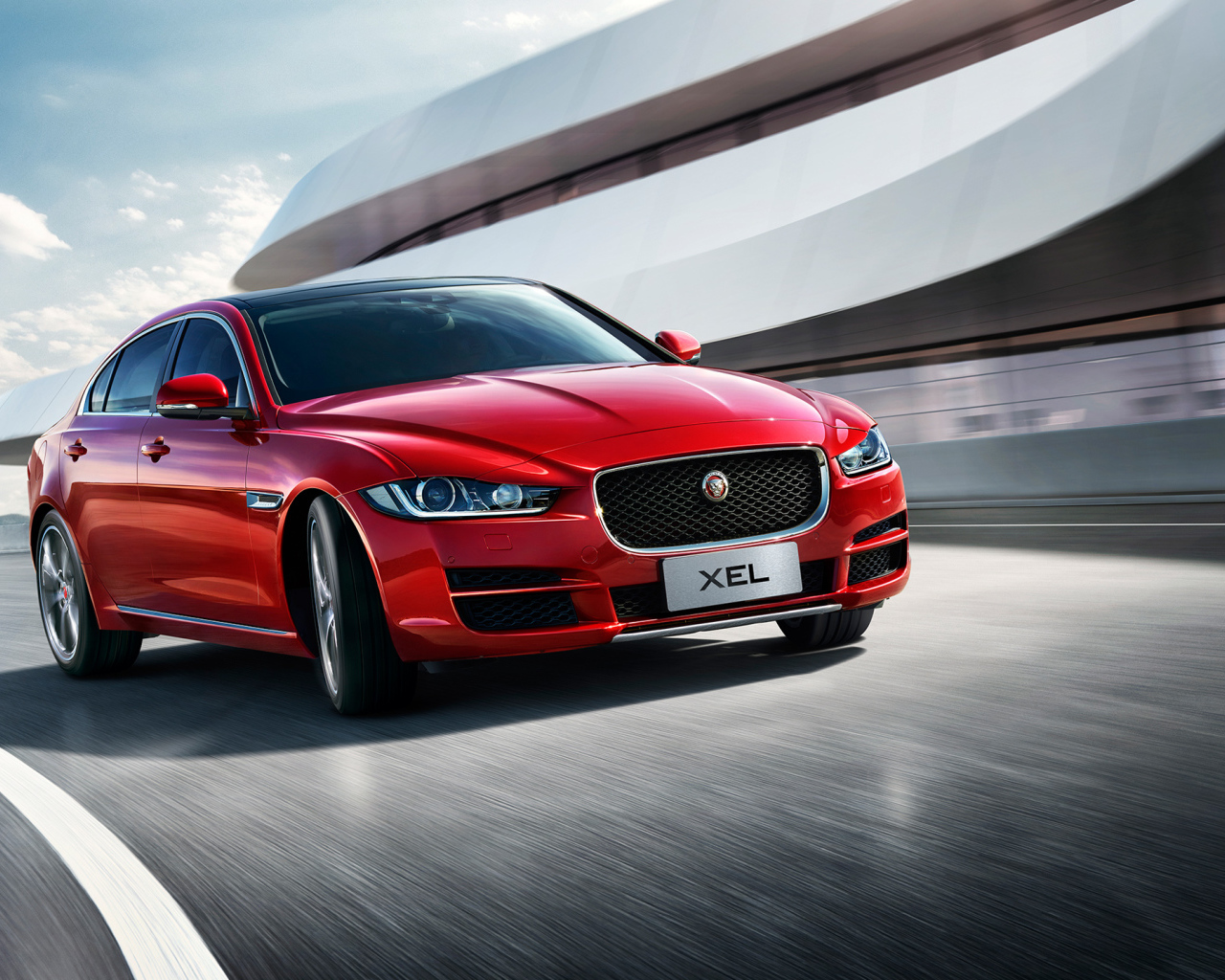 Красный автомобиль Jaguar XEL, 2018 на трассе