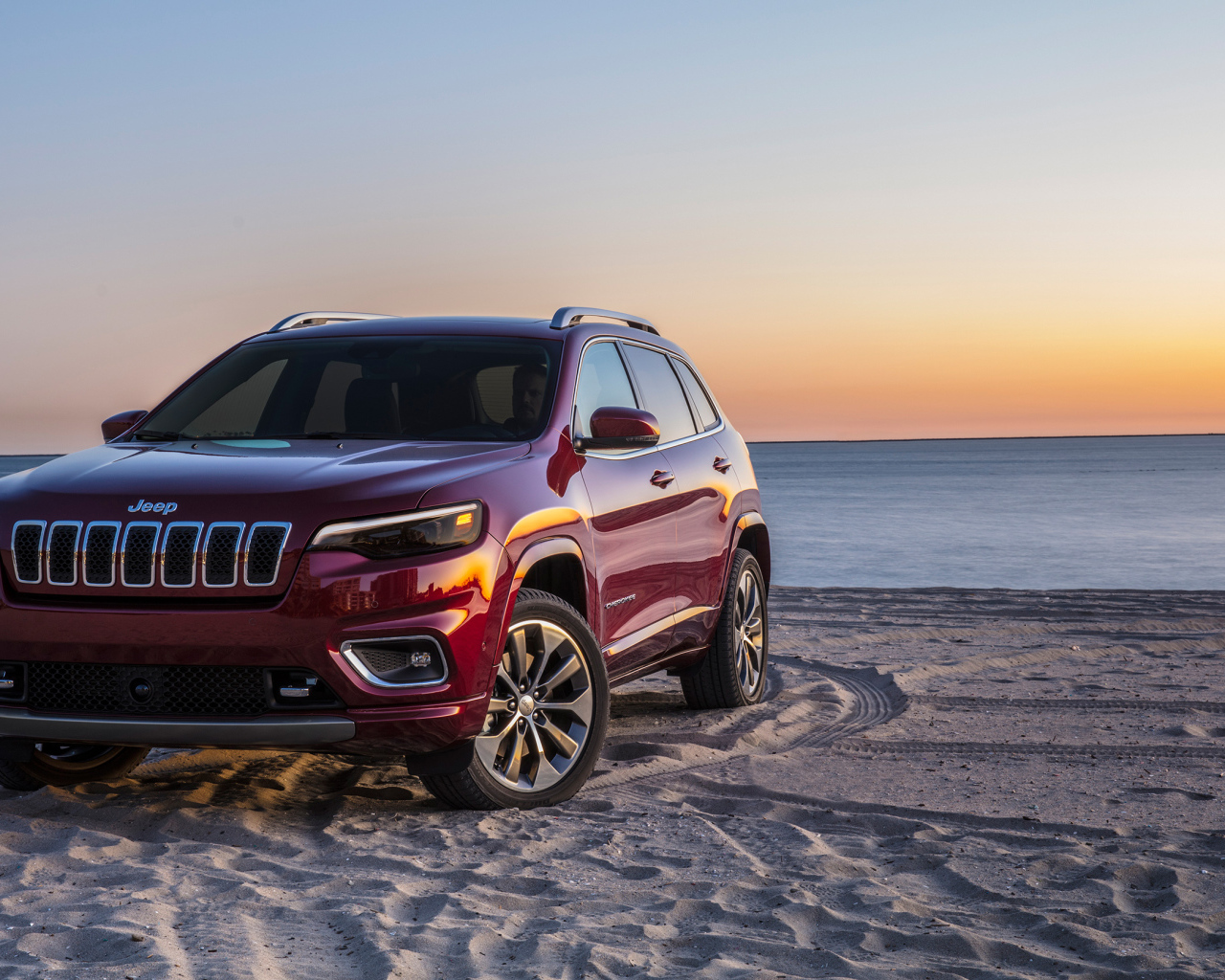 Бордовый внедорожник Jeep Cherokee Overland, 2018 на пляже