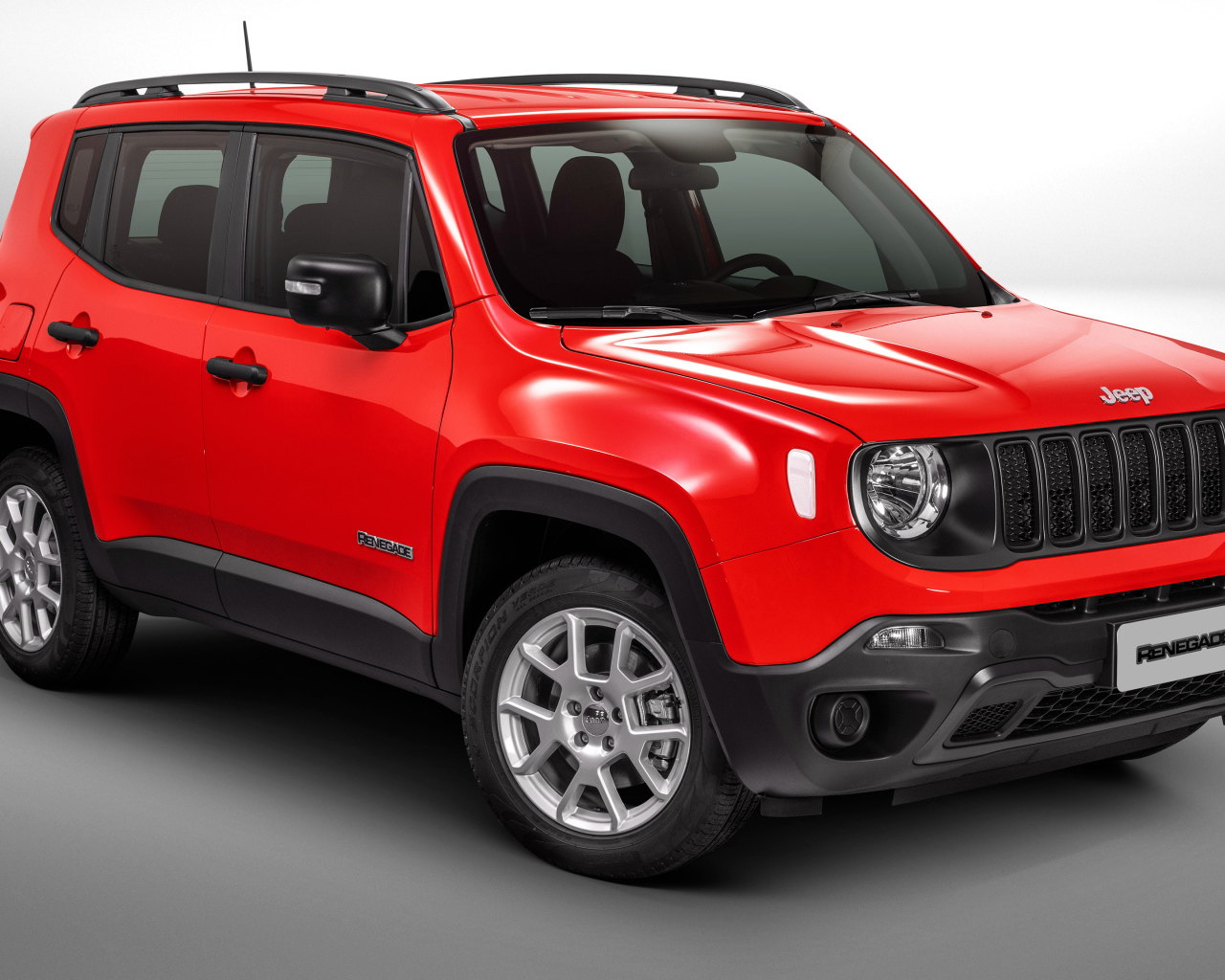 Красный автомобиль Jeep Renegade Sport на сером фоне