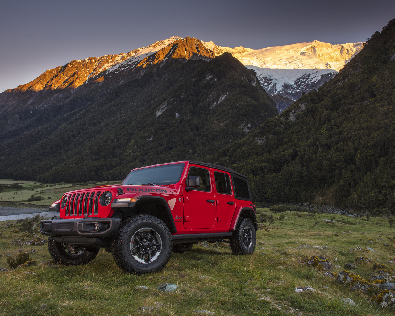 Красный автомобиль Jeep Wrangler на фоне гор