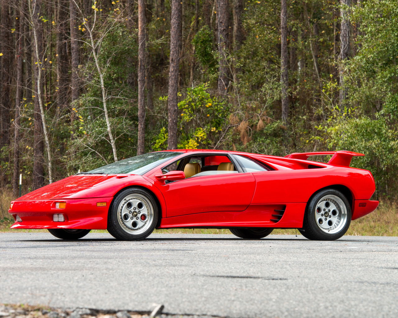 Красный спортивный автомобиль Lamborghini Diablo на фоне леса