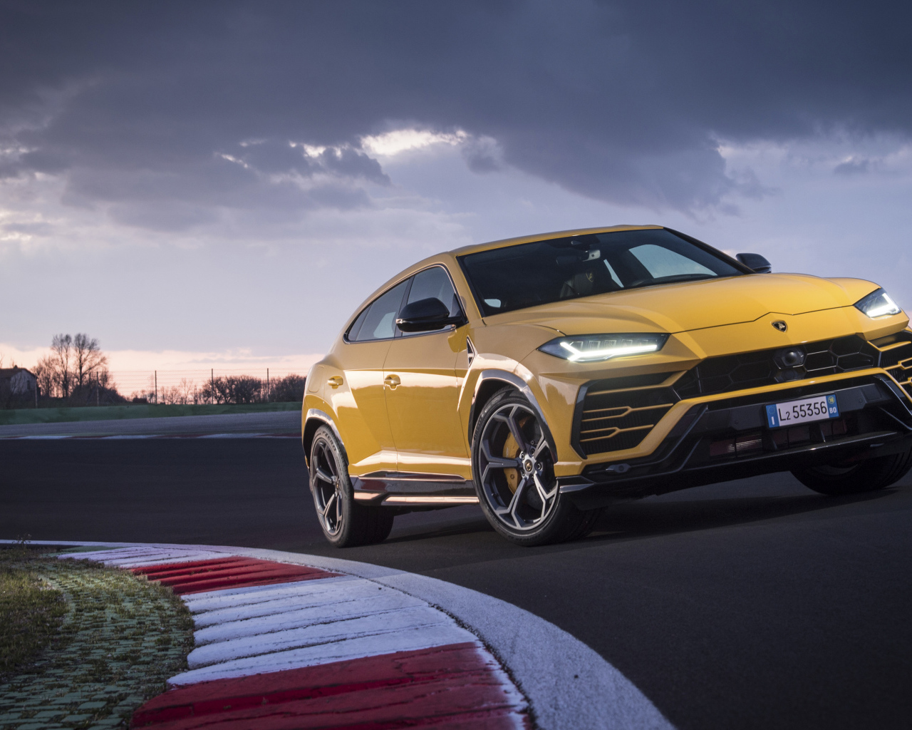 Желтый внедорожник Lamborghini Urus  едет по дороге