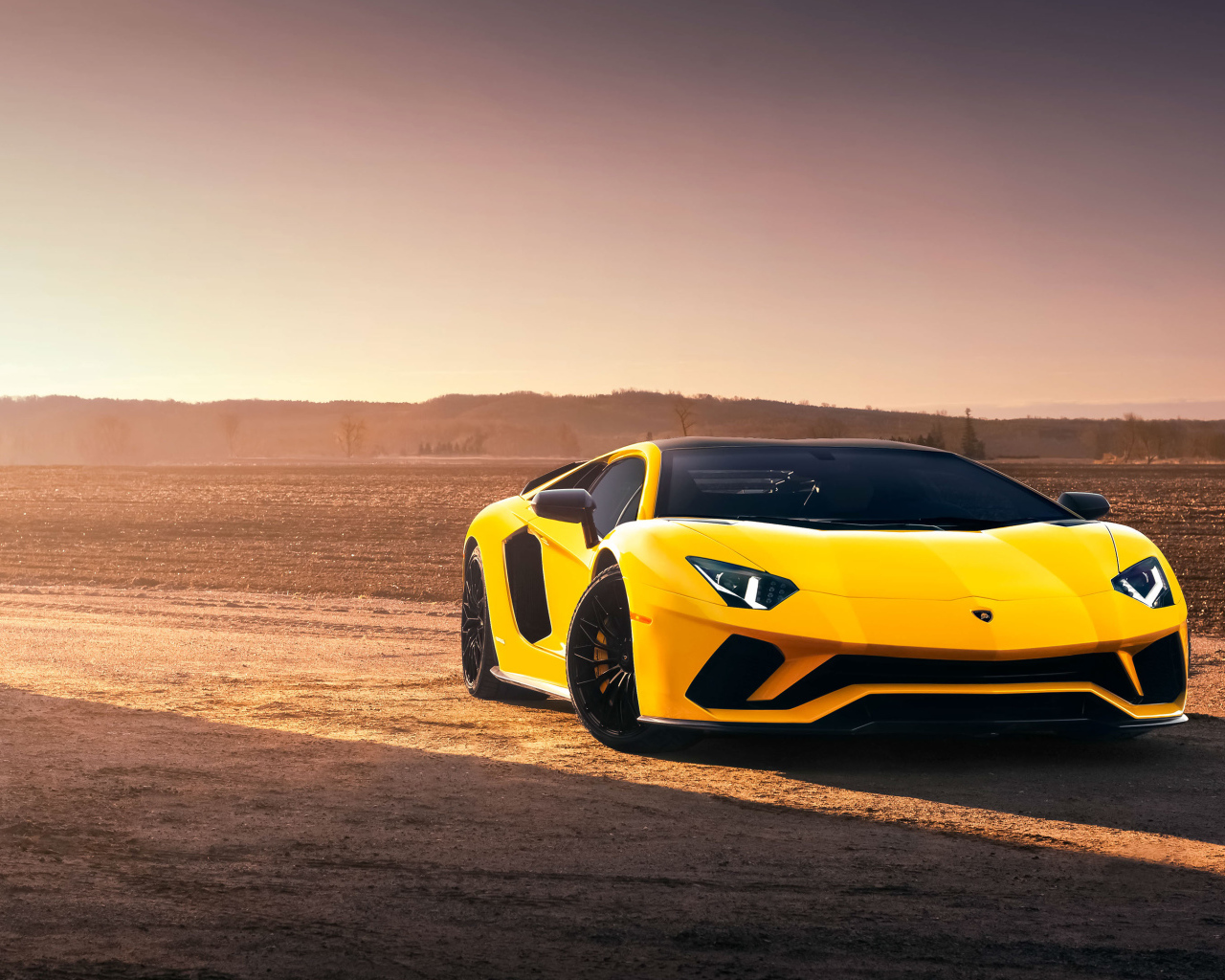Желтый спортивный автомобиль Lamborghini Aventador S в лучах солнца