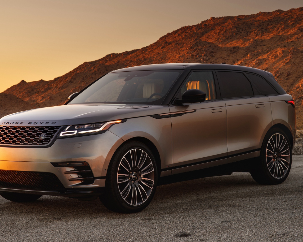 Серебристый внедорожник Land Rover 2018 года на фоне скалы 