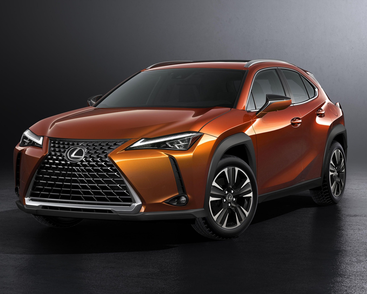 Оранжевый автомобиль Lexus UX, 2019 на сером фоне