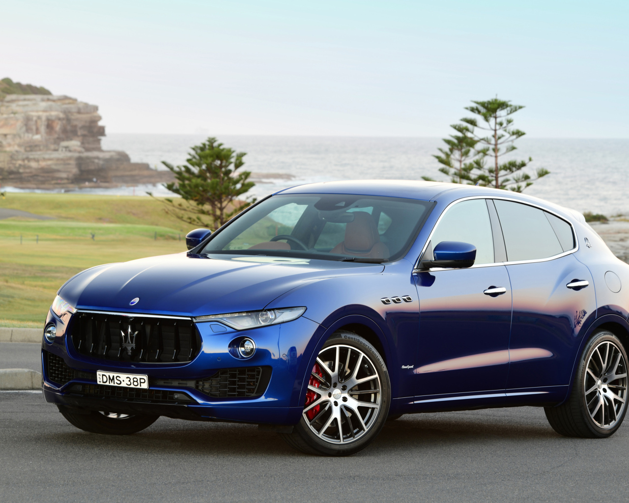 Синий автомобиль Maserati Levante на фоне океана 