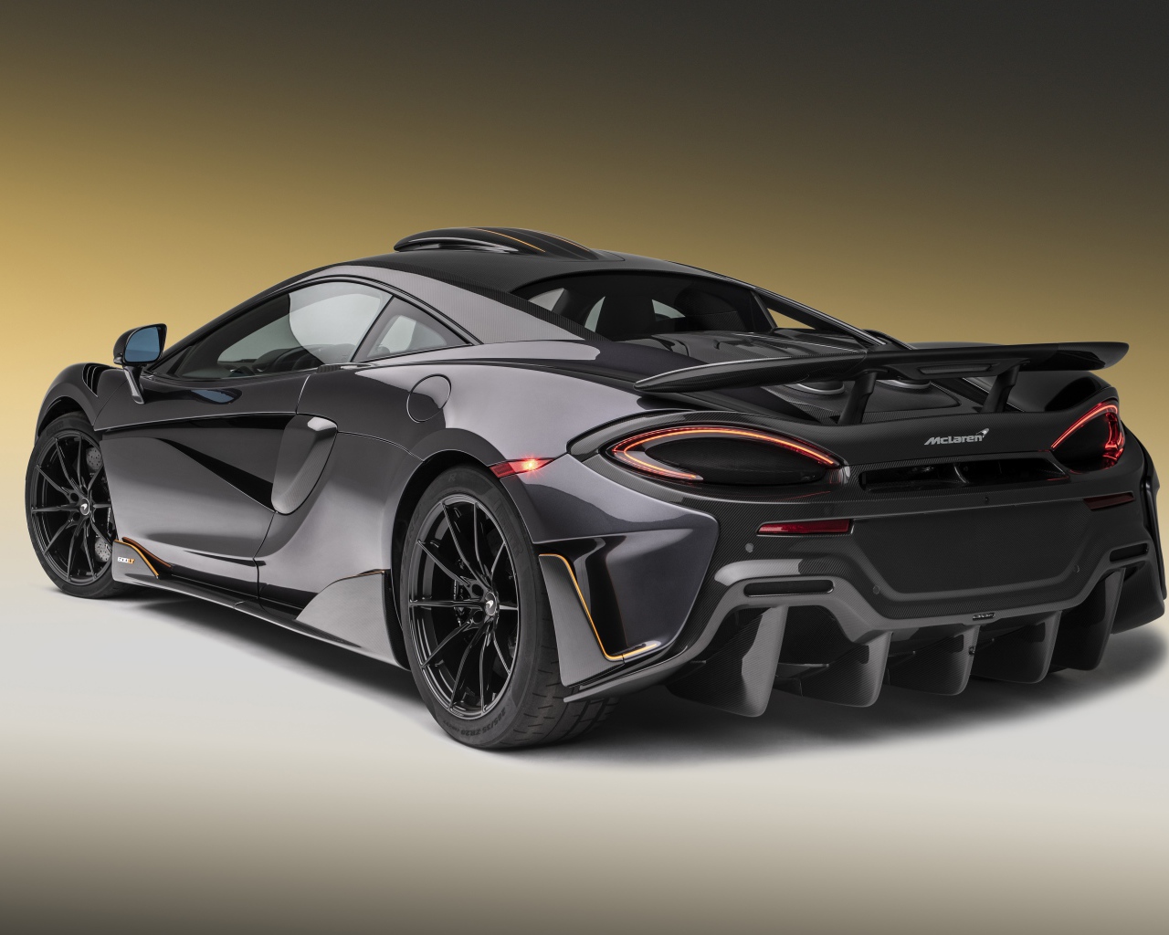 Черный спортивный автомобиль  McLaren 600LT, 2019 года вид сзади