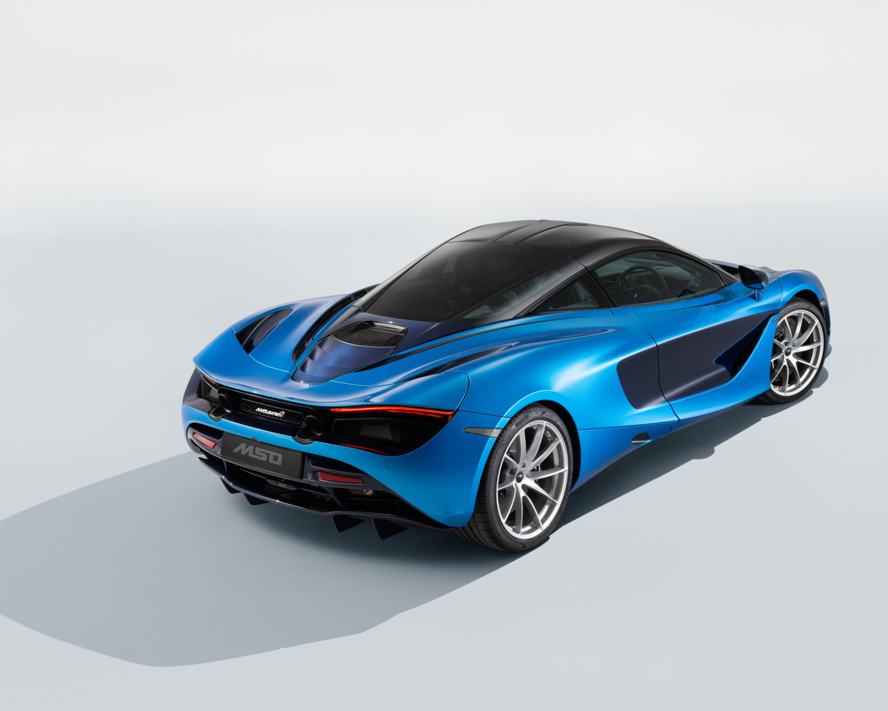Голубой быстрый автомобиль McLaren 720S, 2018 года вид сзади