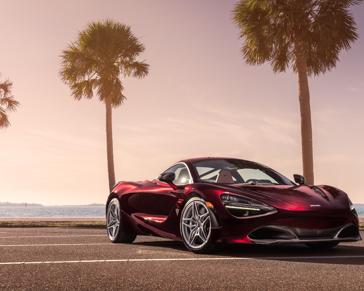 Бордовый спортивный автомобиль McLaren 720S, 2018 на фоне пальм