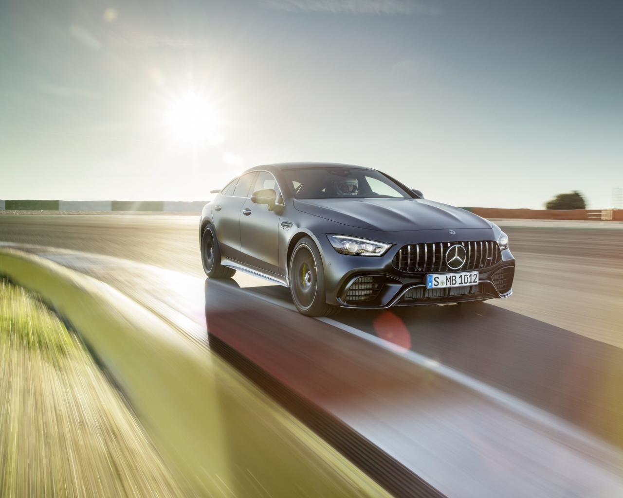 Серебристый автомобиль Mercedes-AMG GT4, 2018 года на скорости 