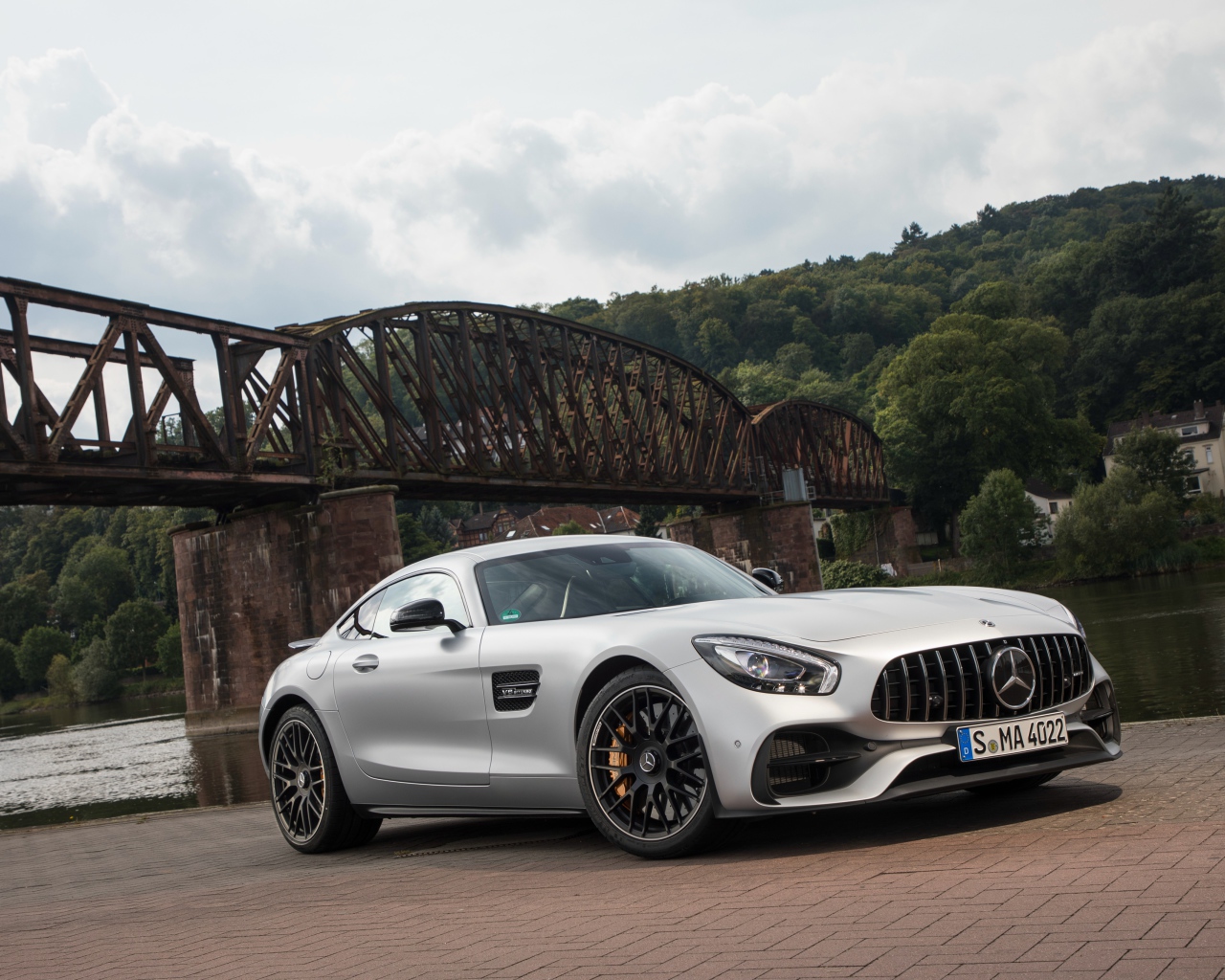 Серебристый автомобиль Mercedes-AMG GT на фоне моста