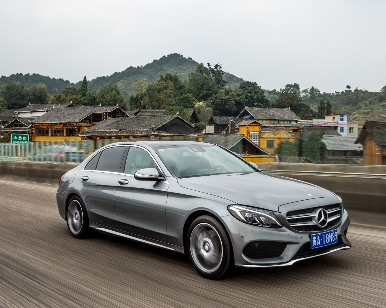 Серебристый автомобиль Mercedes-Benz C-Class на трассе