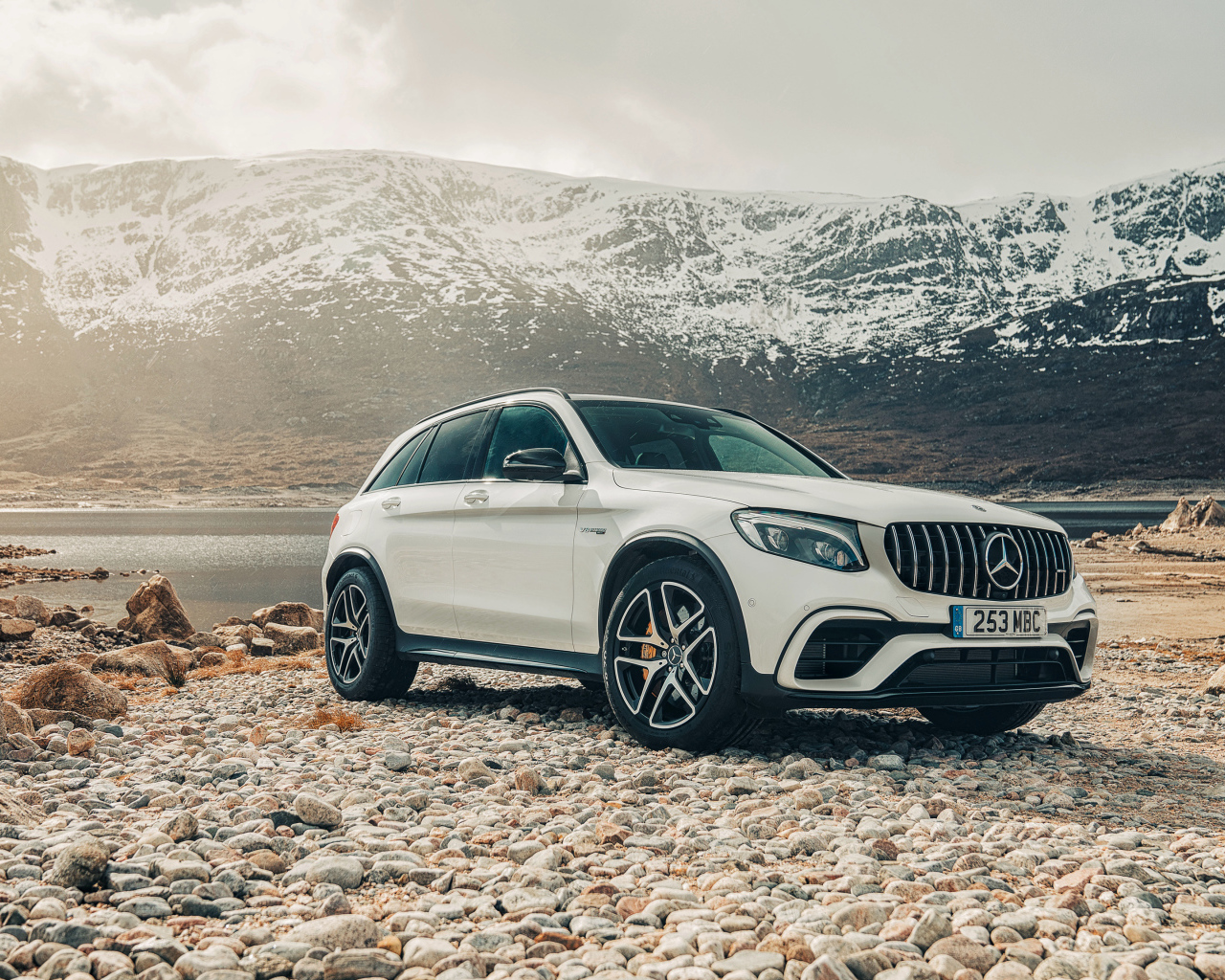 White SUV Mercedes AMG GLC 63 S, 2018 against the backdrop of the mountains