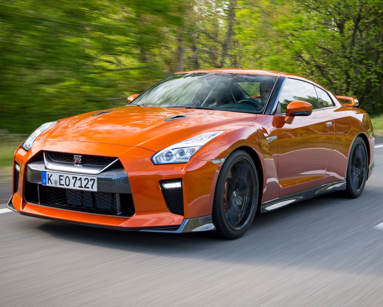 Оранжевый автомобиль Nissan GT-R на трассе