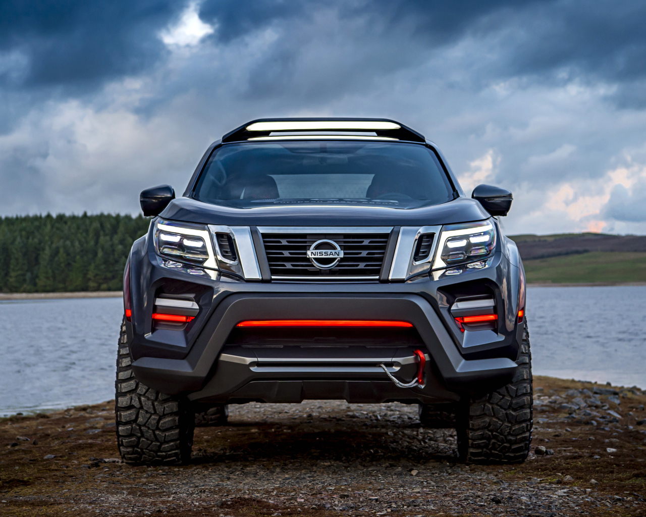 Внедорожник Nissan Navara на фоне грозового неба