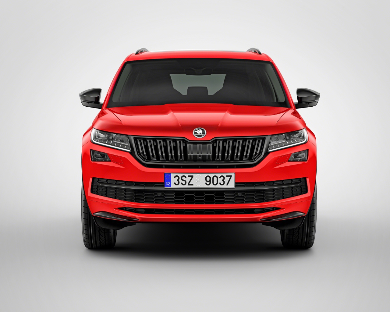 Красный автомобиль Skoda Kodiaq на сером фоне