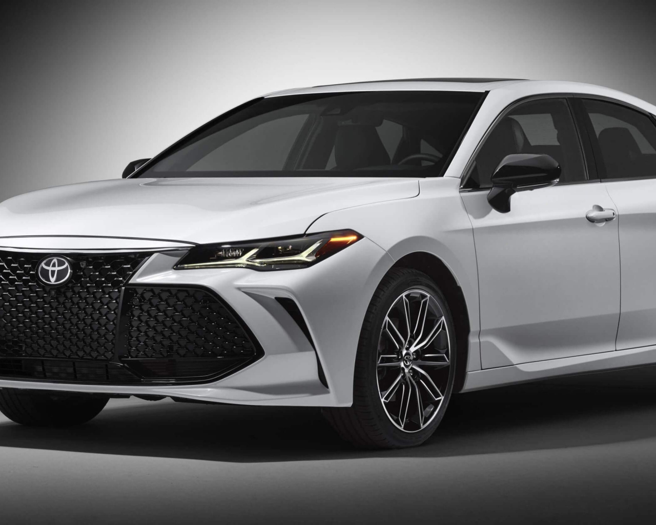 Белый автомобиль Toyota Avalon 2019 на сером фоне