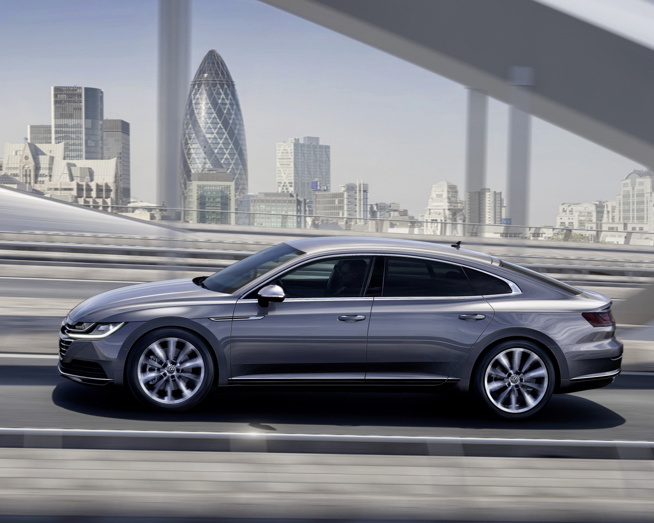 Серебристый автомобиль Volkswagen Arteon, 2018 года на фоне города