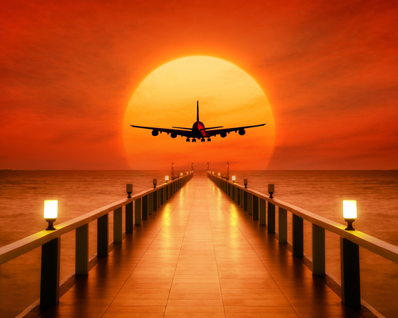 Самолет идет на посадку на закате солнца над океаном