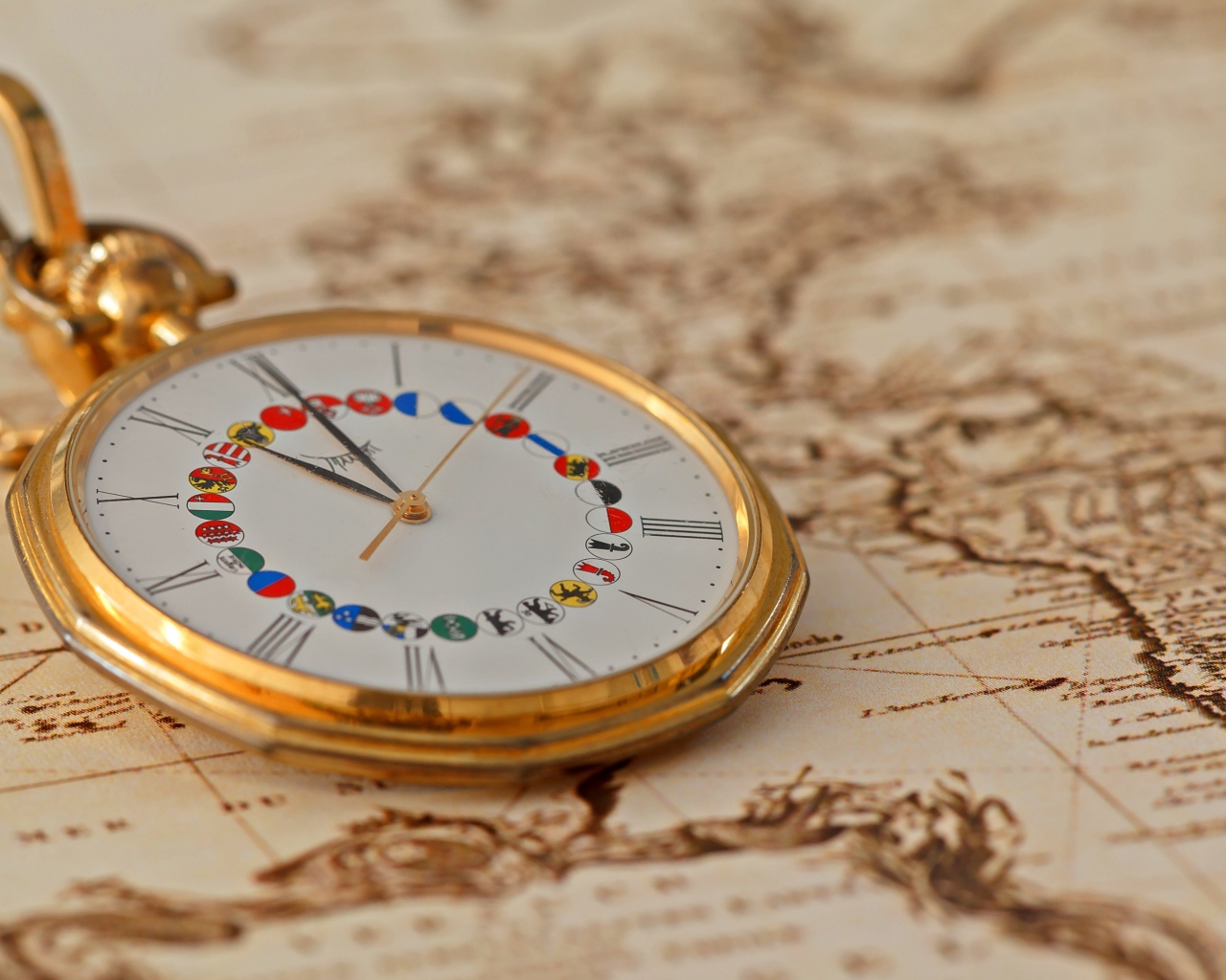 Карманные часы в золотой оправе лежат на карте