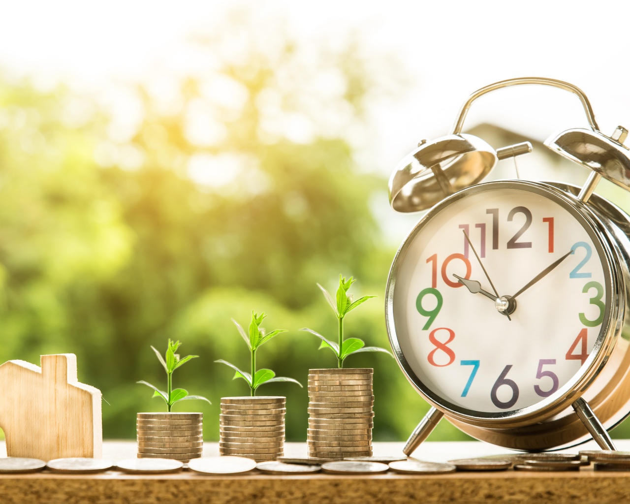 Будильник с монетами с зелеными ростками