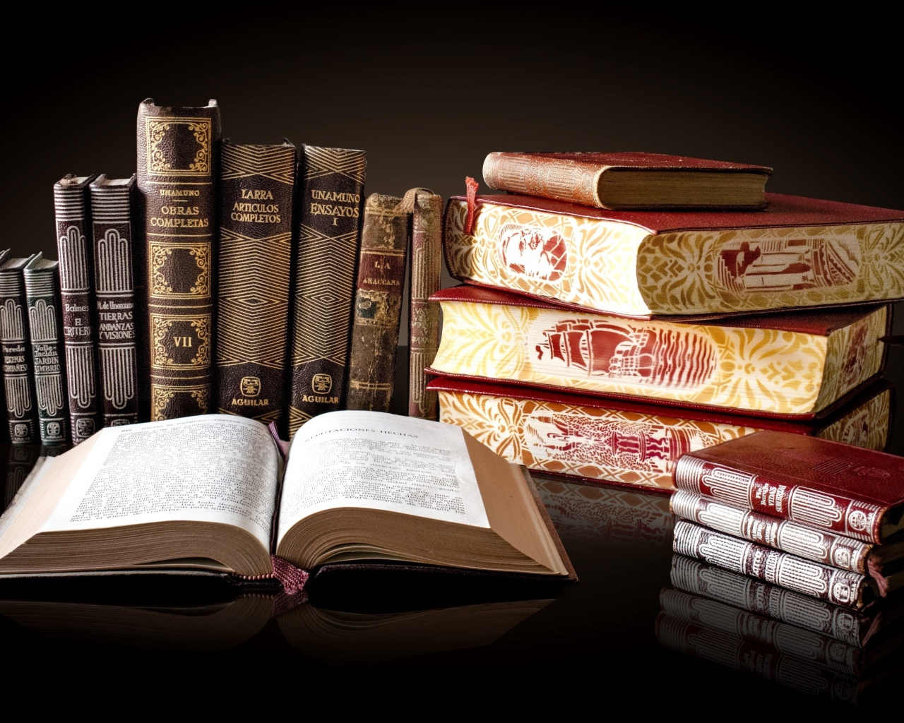 Красивые книги отражаются в зеркальной поверхности стола