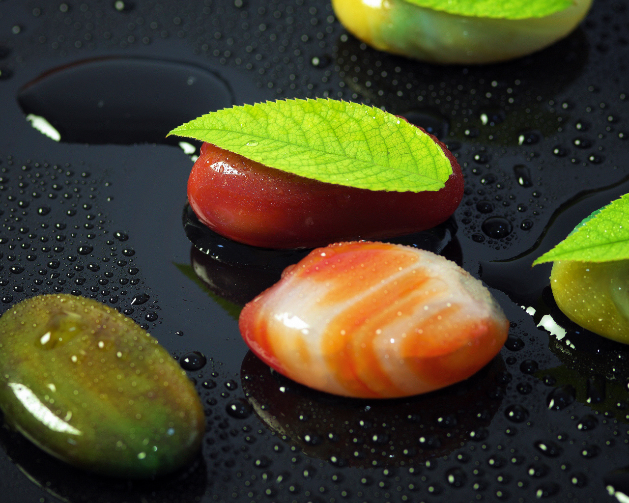 Красивые камни на черной мокрой поверхности