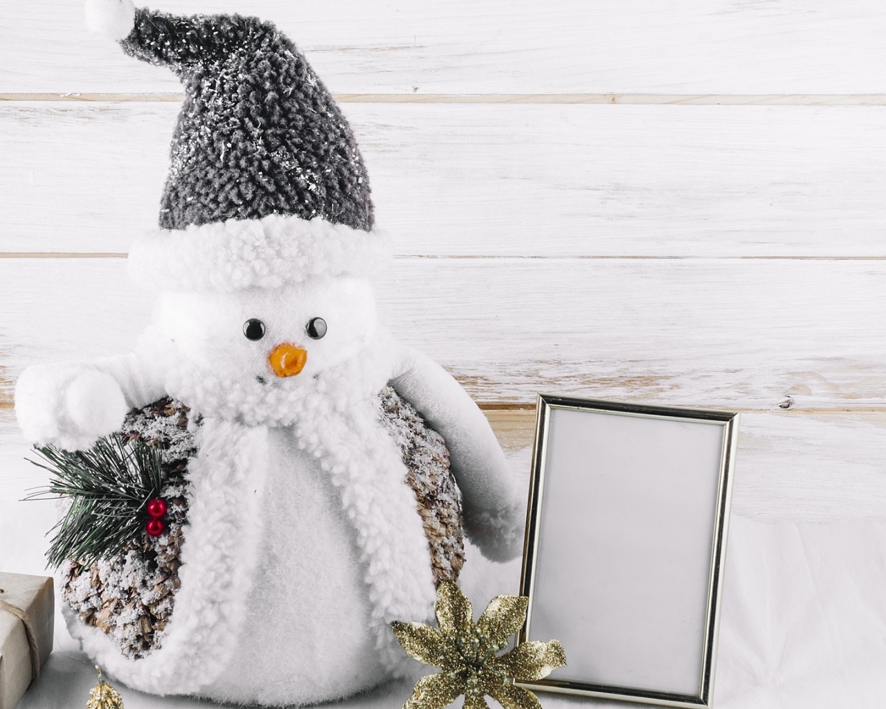 Большой игрушечный снеговик на деревянном фоне