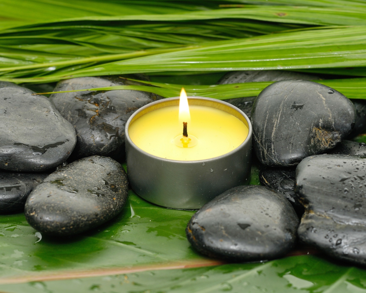 Зажженная свеча и черные камни для SPA