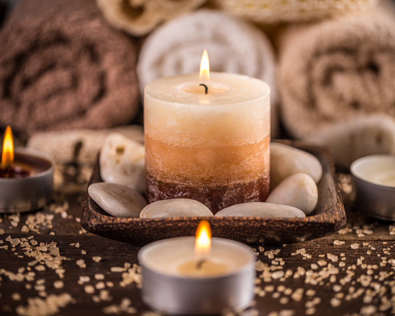 Зажженная свеча с камнями для SPA процедур