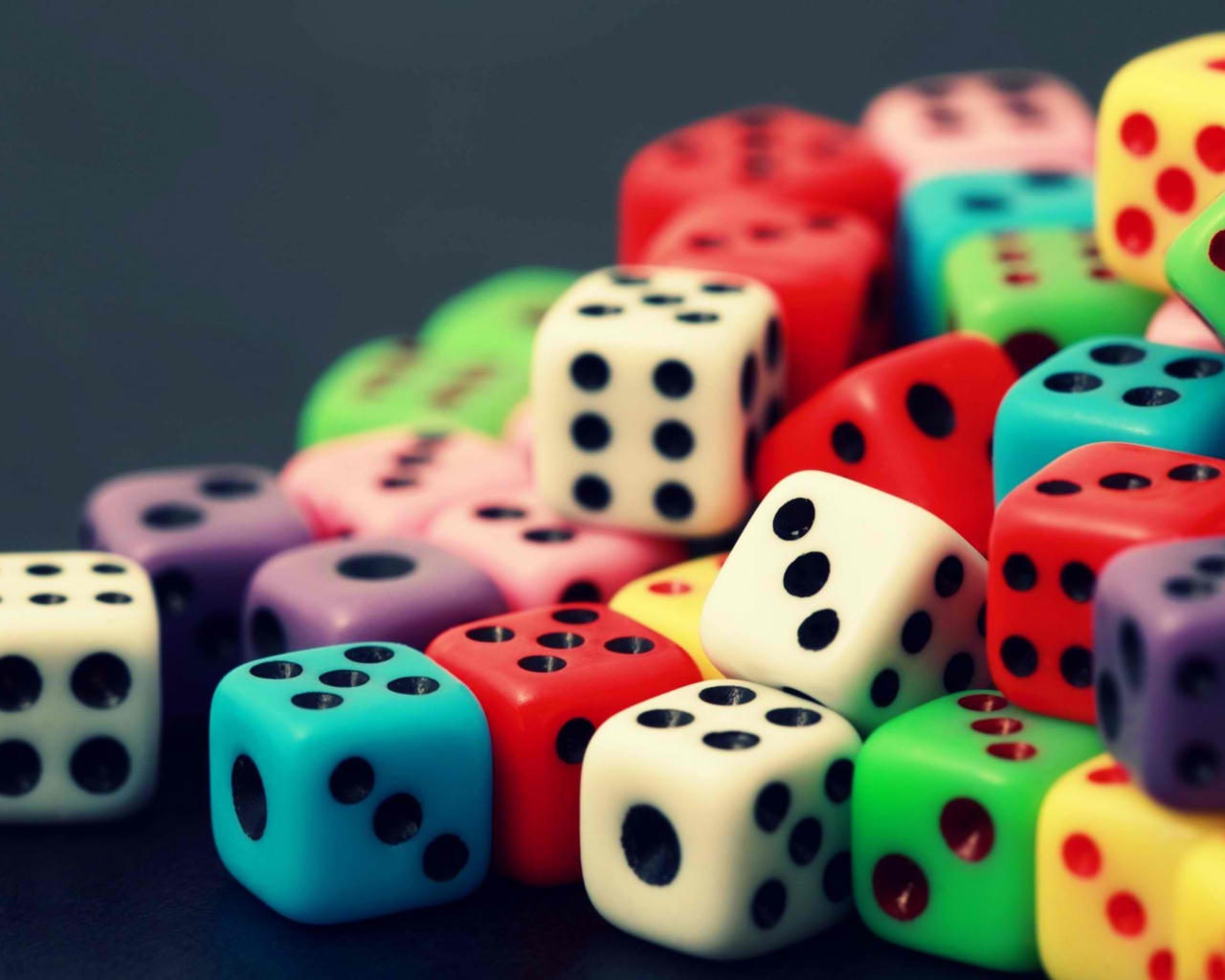 Разноцветные игральные кости на сером столе 