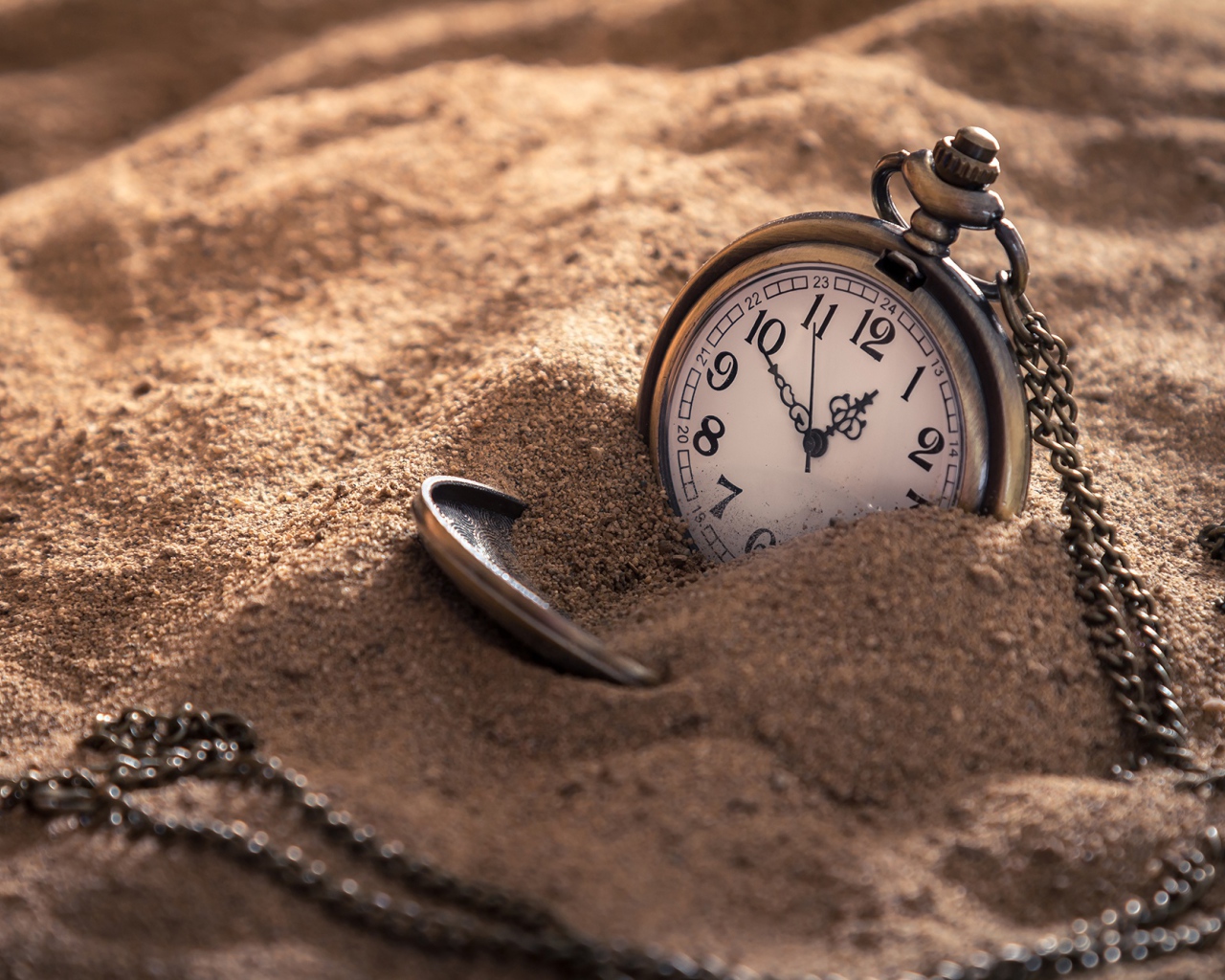 Карманные часы на цепочке в песке 