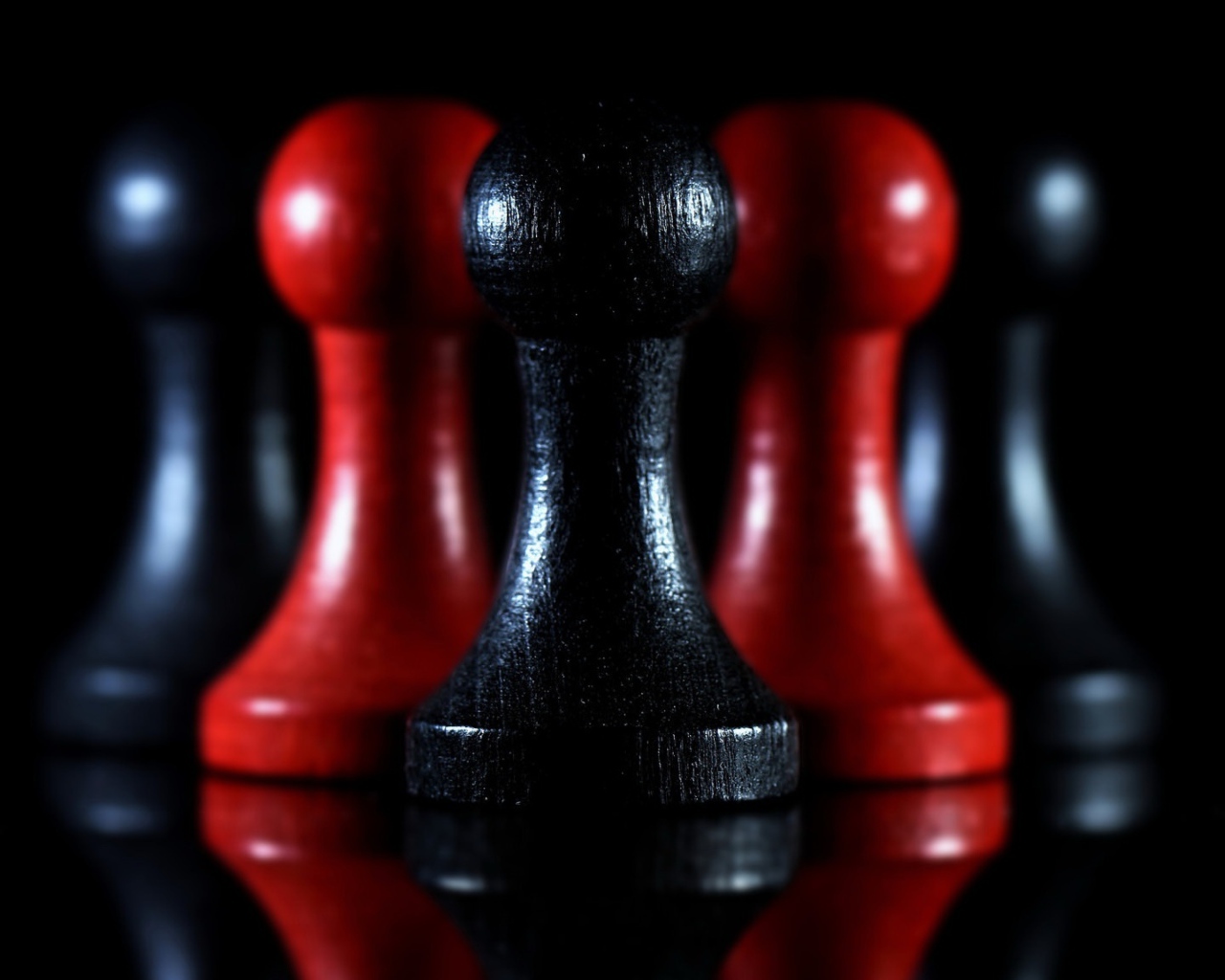 Красные и черные шахматные фигуры на черном фоне