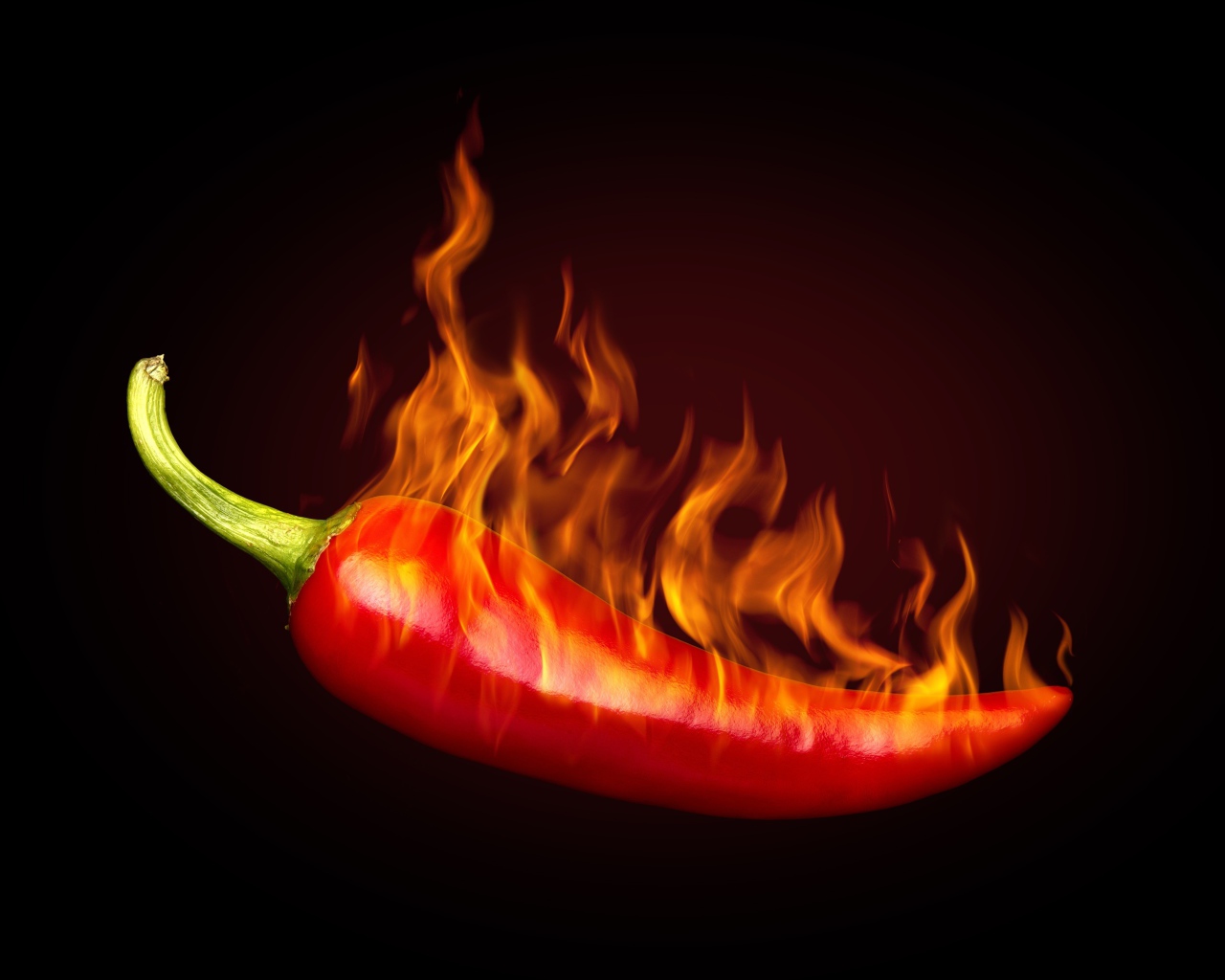 Красный перец с пламенем на черном фоне